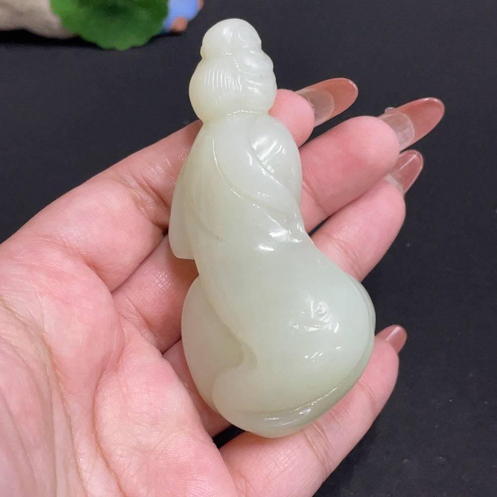 Handheld Hetian jade piece by HUILIU HQ, showcasing intricate craftsmanship and smooth, polished surface, weighs approximately 76.4g.