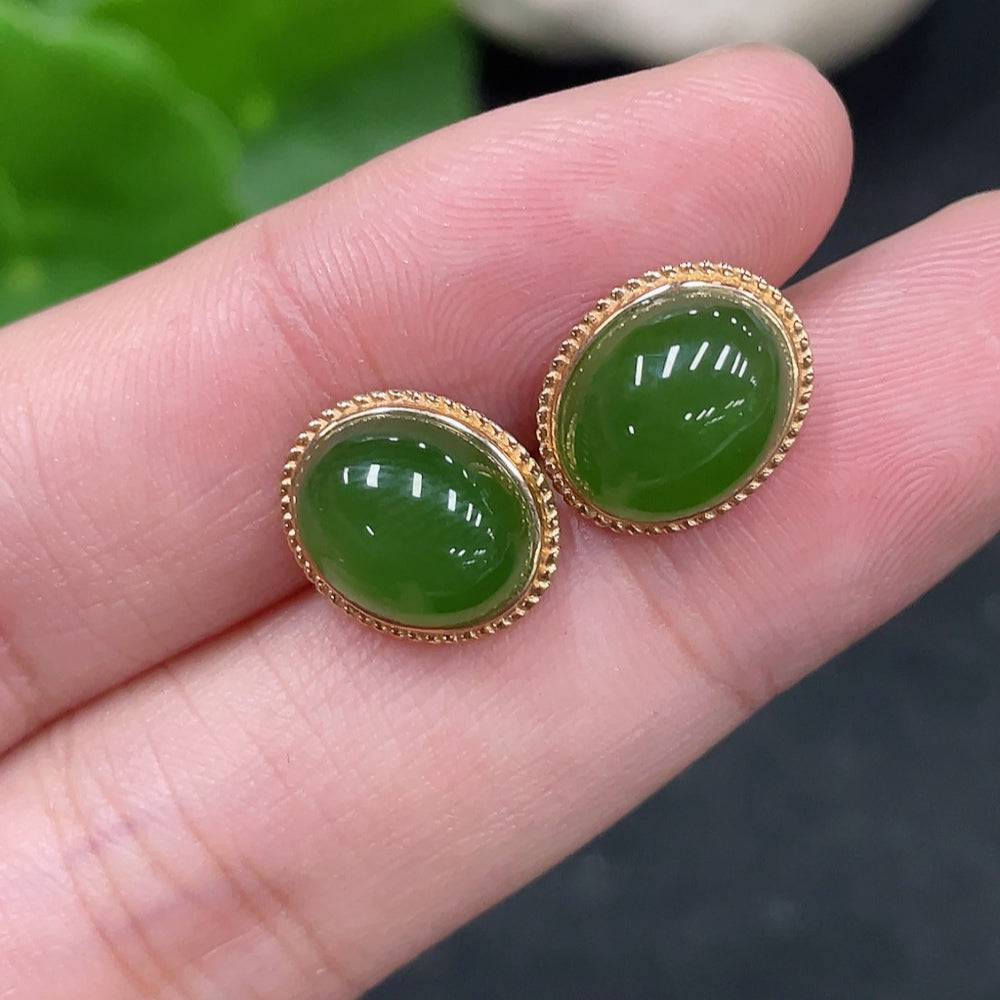 Huiliu certified Hetian Jade cabochon earrings with silver setting, showcasing smooth, polished green jade stones on silver hooks.