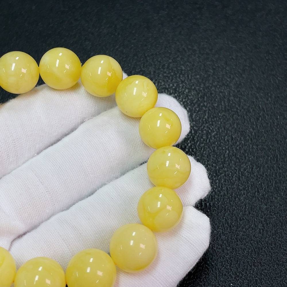 Amber Beeswax bracelet featuring 13mm round amber beads, crafted by HUILIU HQ, showcasing natural amber tones and craftsmanship.
