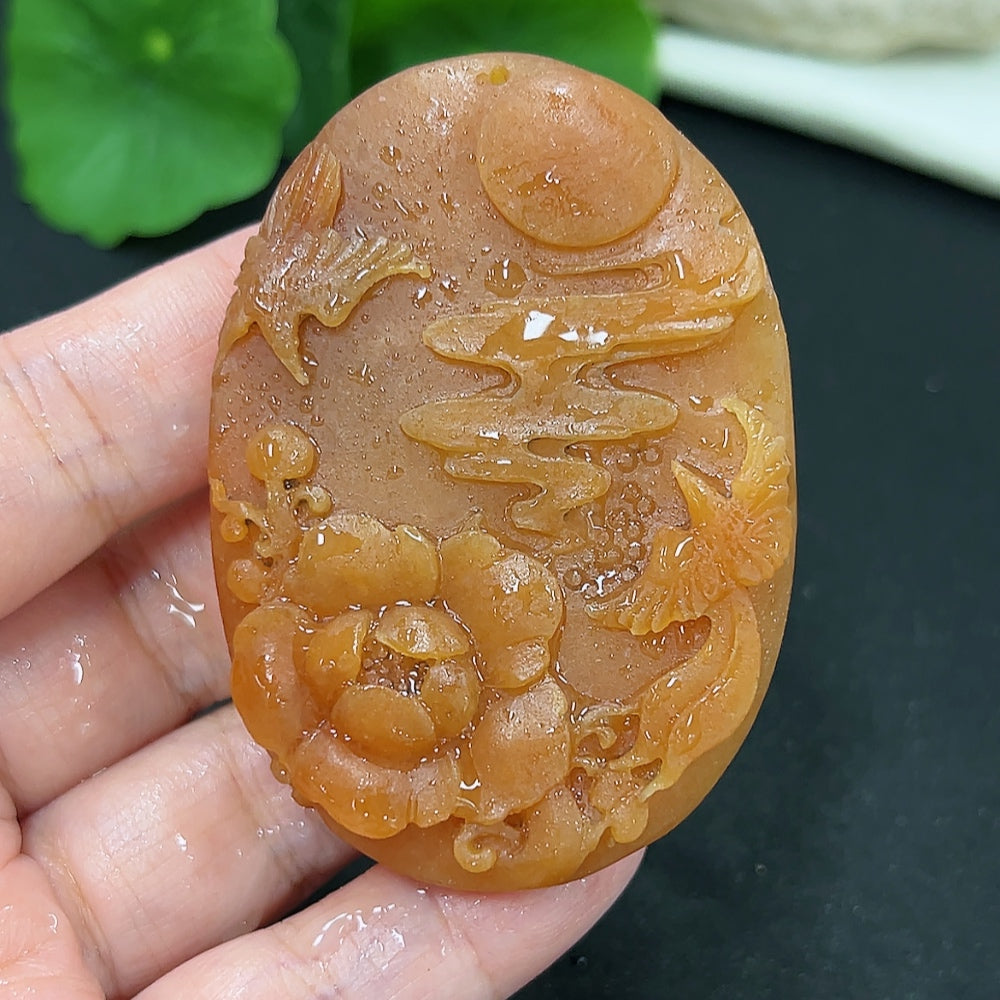 Unpolished jadeite pendant with blossoming wealth and prosperity design, weighing approximately 48.1g, from HKHQ.