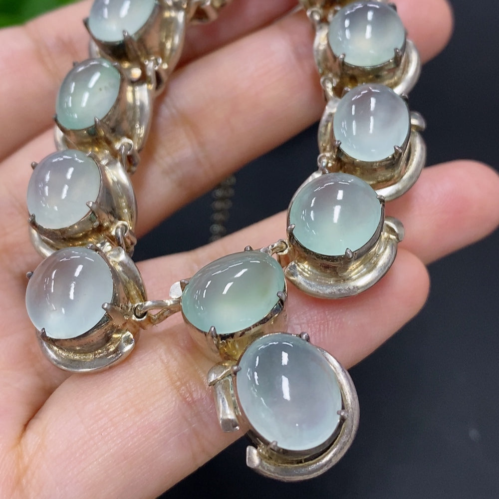 Jadeite cabochon gemstone from HKHQ in a non-gold setting, weighing approximately 61.2 grams, with a smooth polished surface.