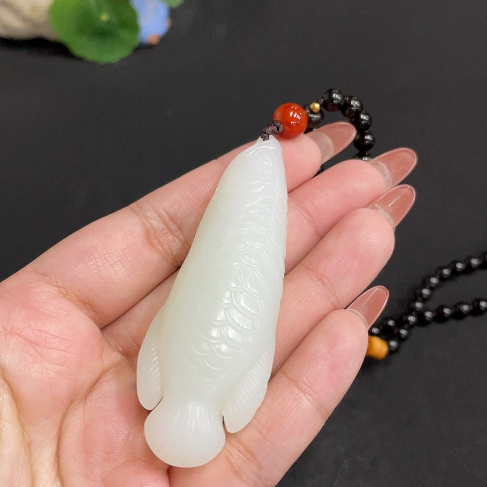 Huiliu certified Hetian jade pendant featuring intricate carvings, showcasing smooth, polished green jade stone.