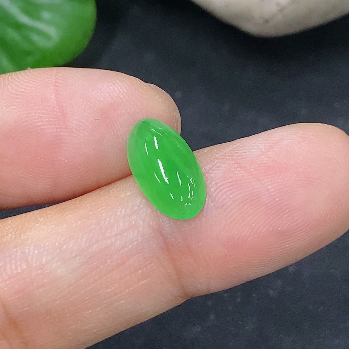 Jadeite cabochon jewelry piece from HKHQ, weighing 0.43g, featuring smooth, polished jadeite with vibrant green color.