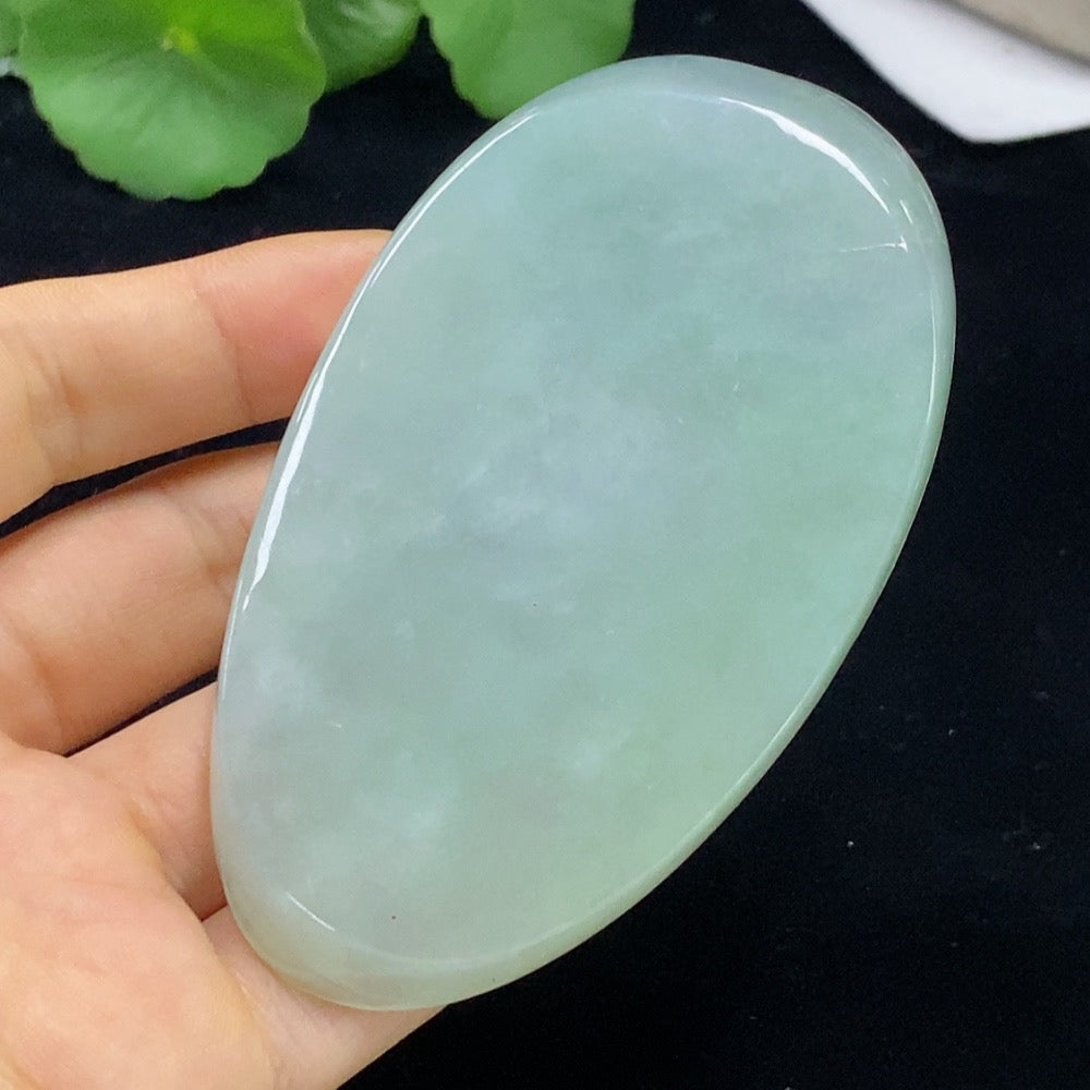 Jadeite Guanyin pendant in green jade, crafted by HUILIU HQ, hanging on a cord with intricate carved details.