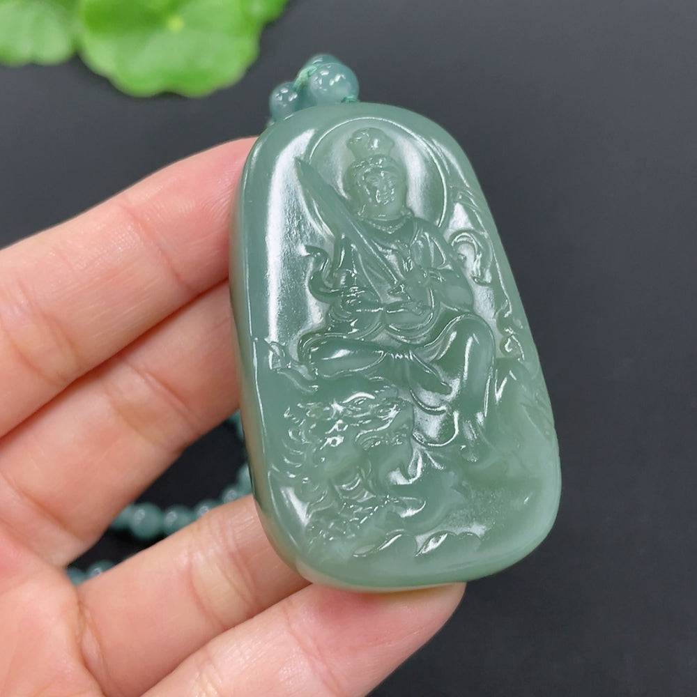 Huiliu Hetian jade pendant featuring Manjushri Bodhisattva with intricate carvings on a polished green jade background.