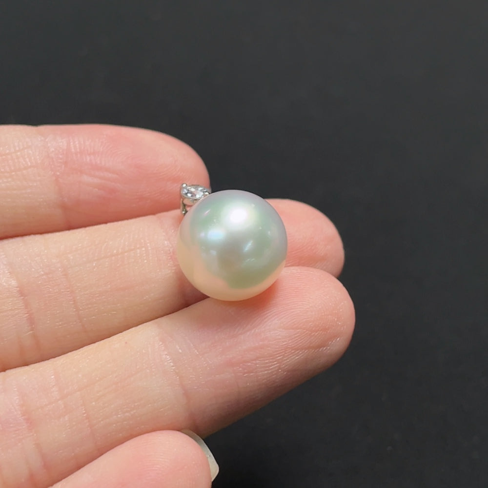 Saltwater pearl pendant with diamond accents on 18K gold necklace, featuring a lustrous pearl and sparkling diamond details.