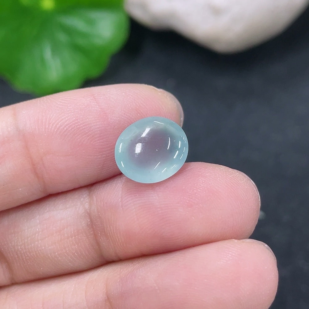 Jadeite cabochon jewelry piece from HKHQ, weighing 0.71g, featuring smooth, polished green jadeite gemstone with natural shine.