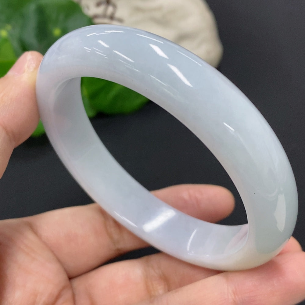 Huiliu certified jadeite round bangle featuring smooth, polished jade with natural green hues, showcasing elegant craftsmanship.