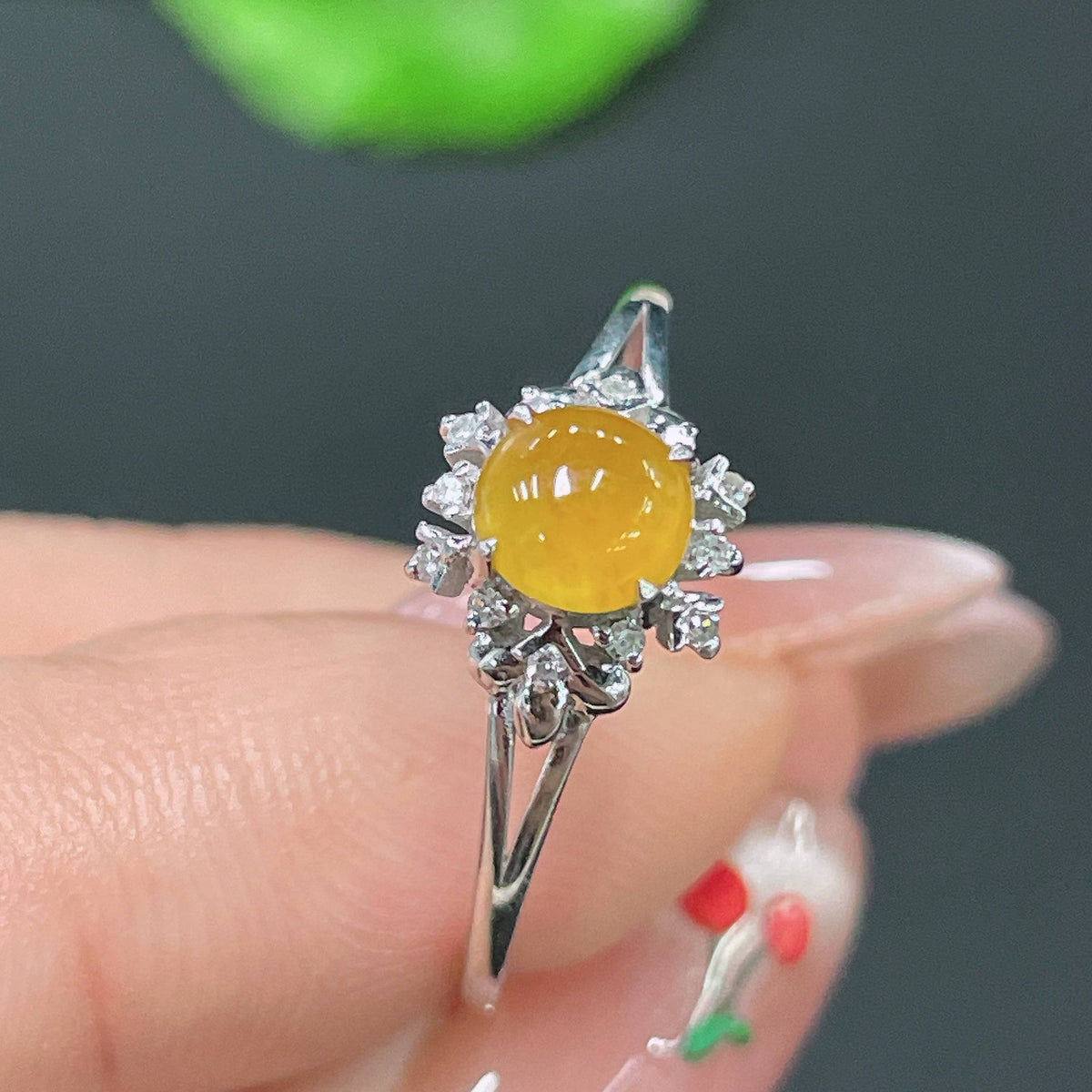 Huiliu certified jadeite ring set with sparkling diamonds, showcasing intricate design and vibrant green jade in a close-up view.