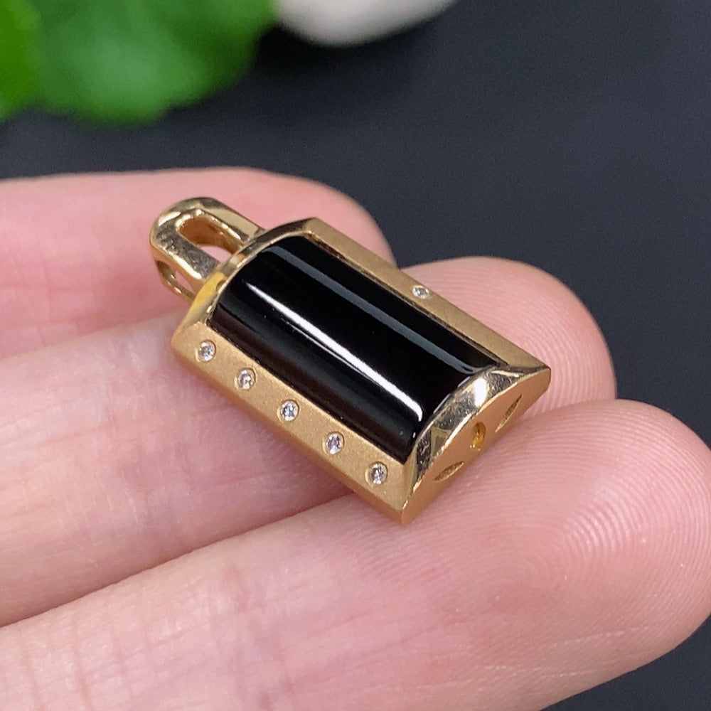 Jadeite inlaid pendant with 18K gold and diamond accents, featuring a detailed design, hanging on a delicate chain.