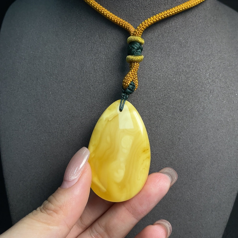 Amber beeswax pendant with rope, crafted by HUILIU HQ, featuring warm amber tones and natural beeswax detailing.