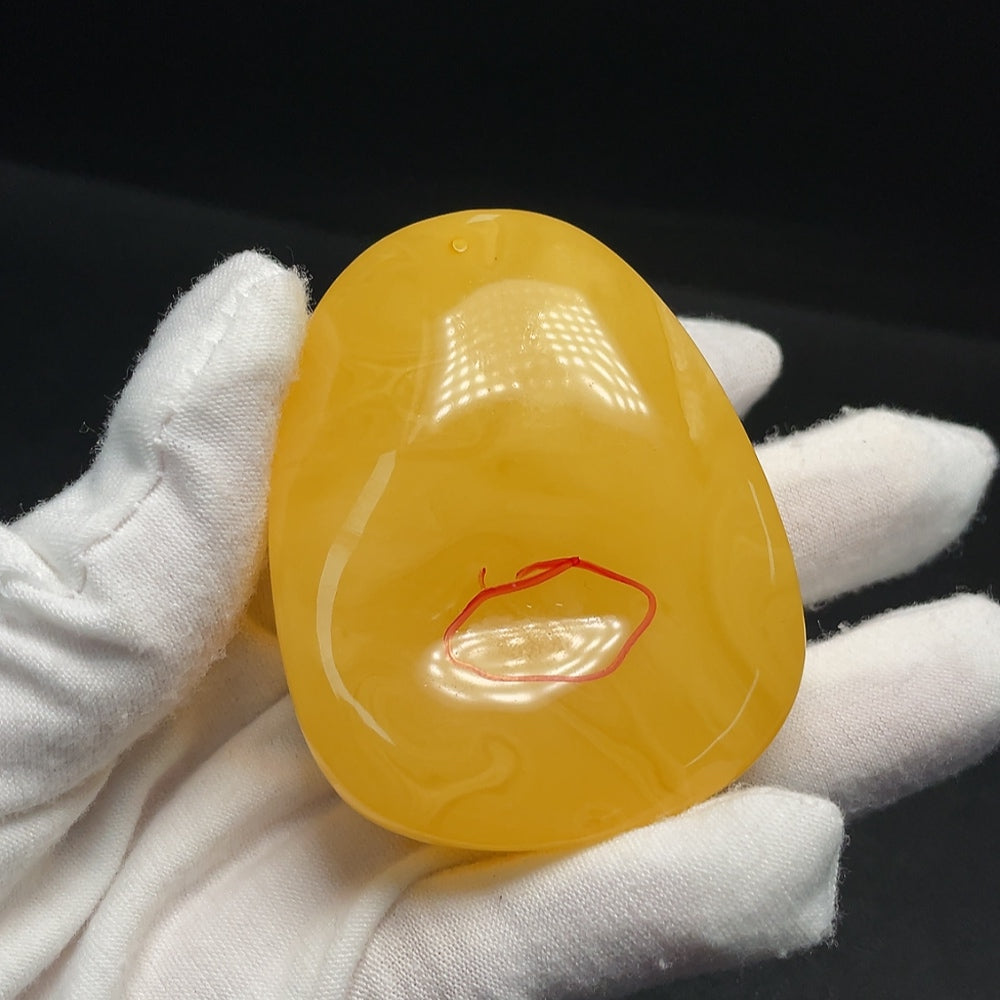 Amber beeswax pendant with visible partial repairs, crafted by HUILIU HQ, showcasing natural amber and handcrafted details.