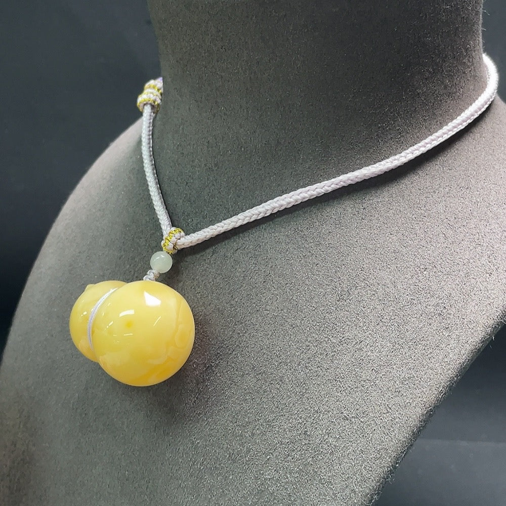 Amber beeswax pendant with Hetian jade and rope, crafted by HUILIU HQ, featuring natural amber and green jade accents.