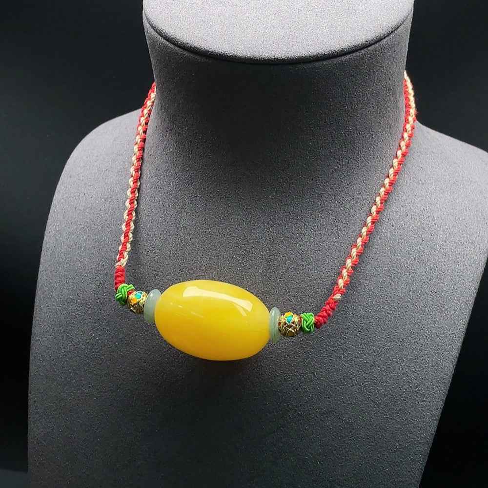 Amber beeswax pendant with jadeite set on a rope, HUILIU HQ certified amber jewelry, close-up showing natural amber and jadeite details.