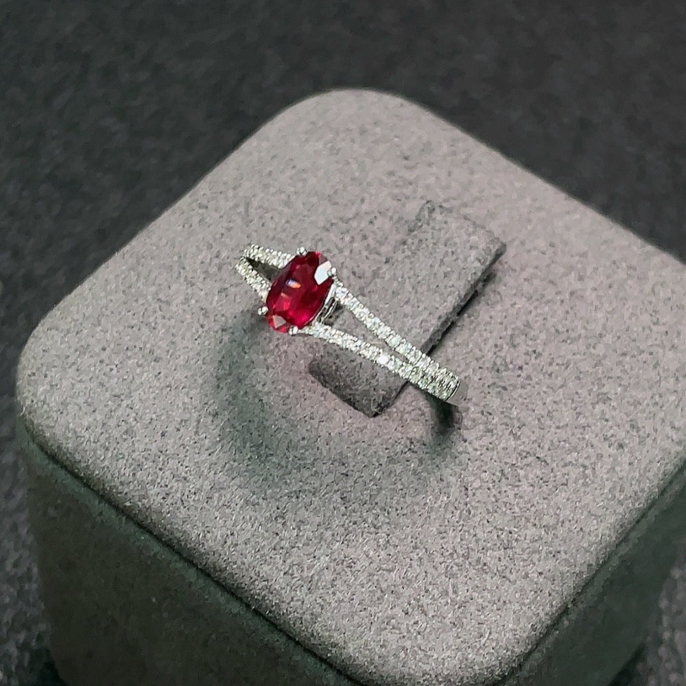 18K ruby ring with diamond accents, size 12, featuring a 5.9x3.2mm ruby gemstone and delicate metalwork.