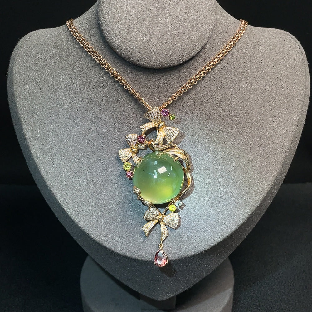 Huiliu certified Prehnite pendant with colorless diamond and tourmaline accents, hanging from a chain, showcasing gemstone details.