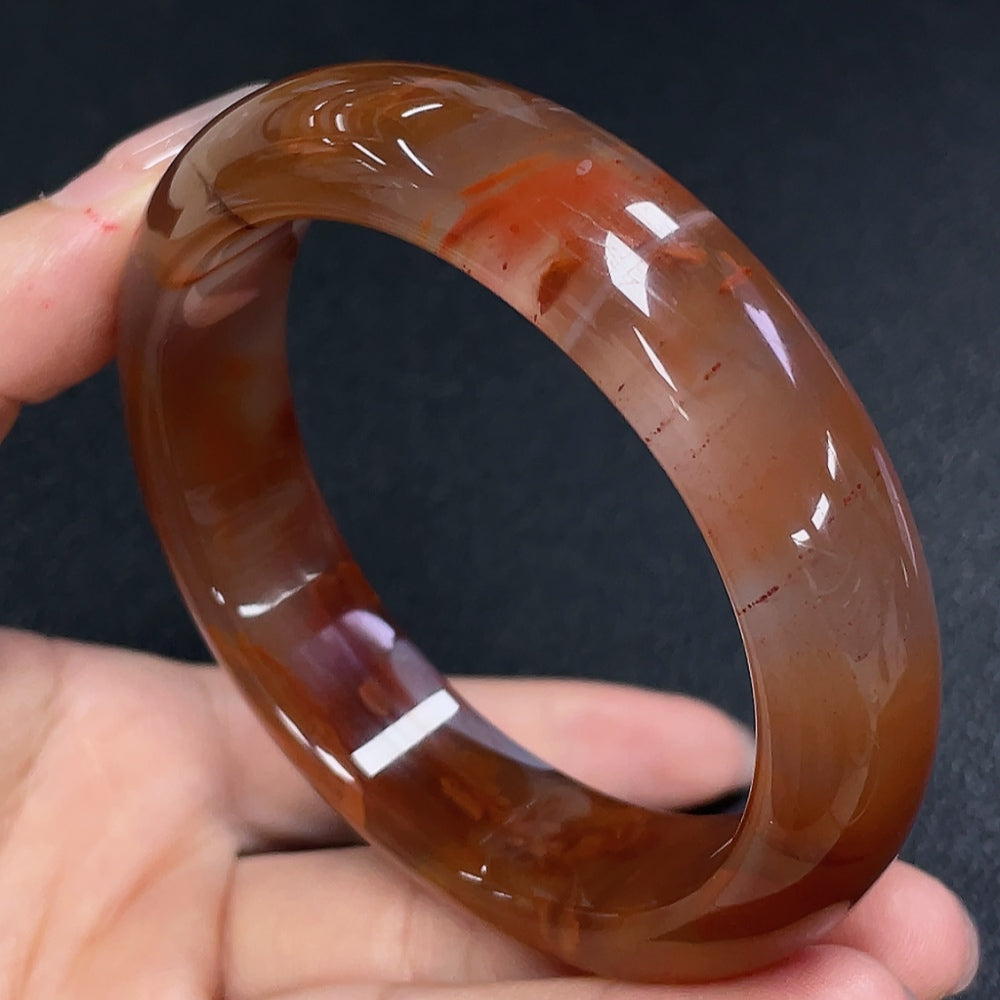 Huiliu Certified South Red Agate gemstone bracelet with visible organic matter, featuring polished round beads on an elastic cord.
