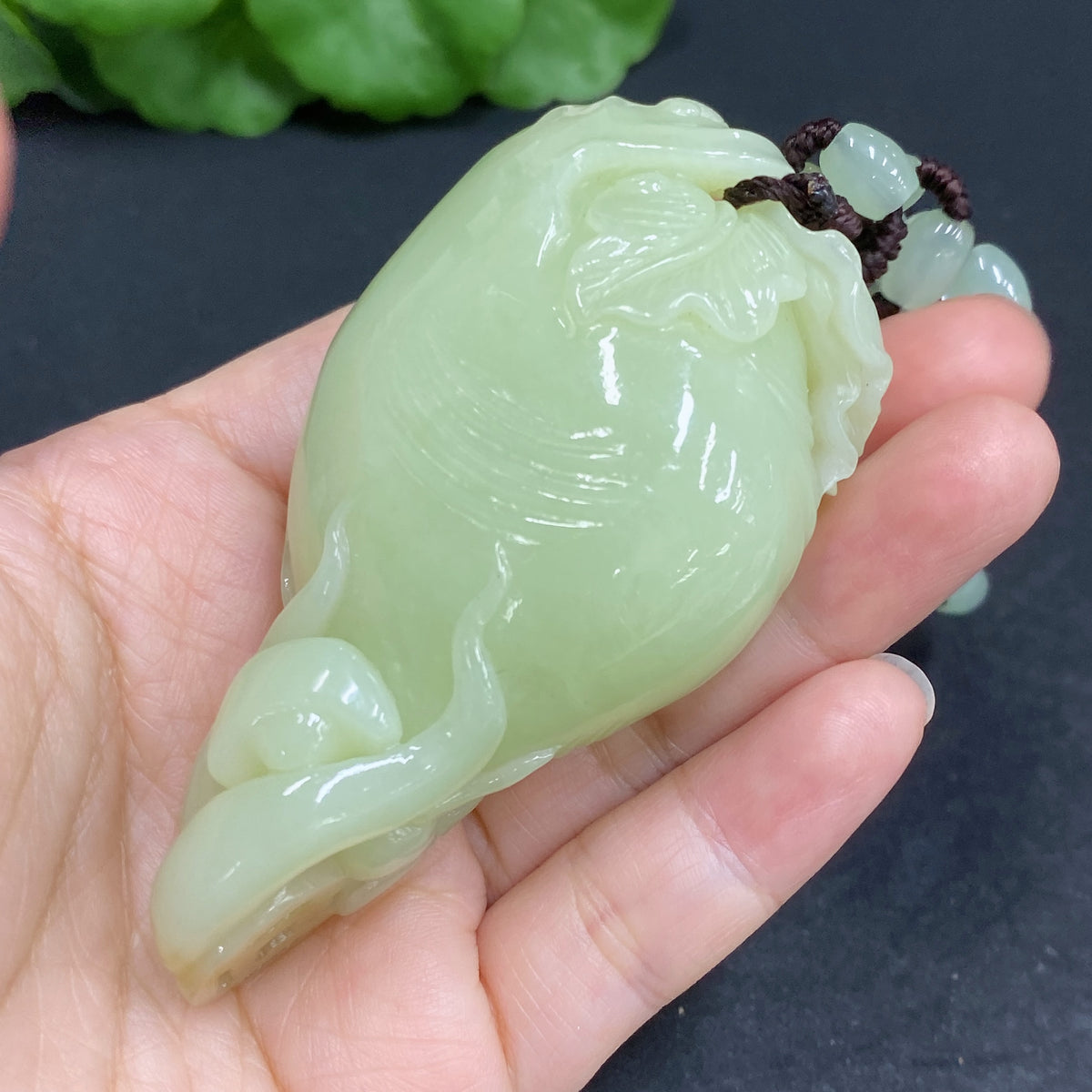 Huiliu certified Hetian jade pendant featuring a detailed ginseng design, smooth polished surface, and natural green hue.