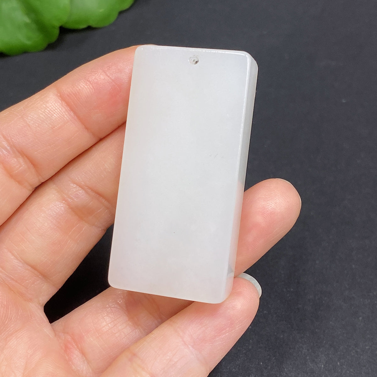 Huiliu certified Hetian jade pendant, plain design, showcasing smooth, pale green jade with polished surface and subtle natural texture.