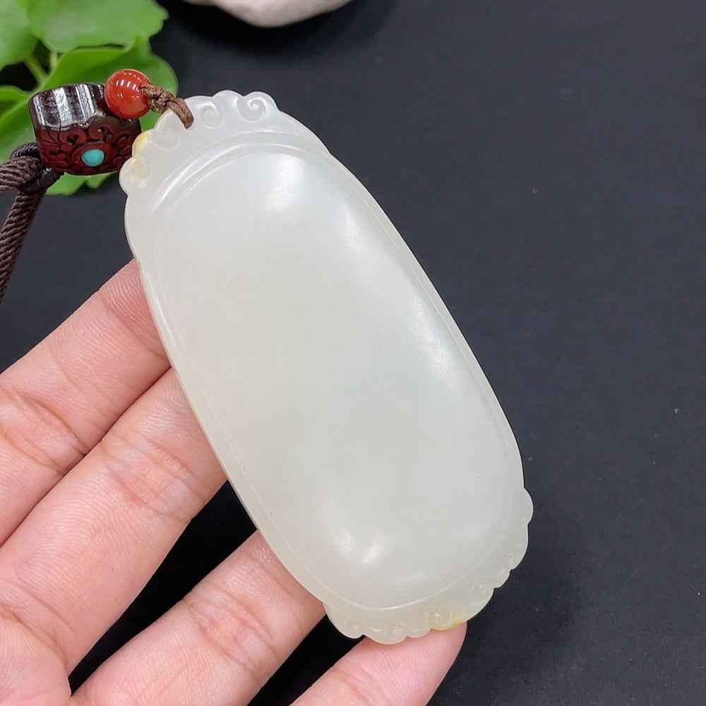 Huiliu certified Hetian jade pendant with plain design, natural skin tone formation, includes cord, showcasing smooth, polished surface.