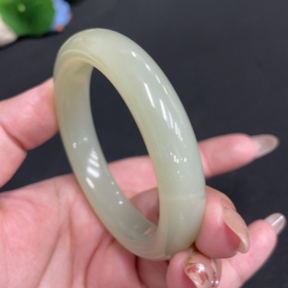 Huiliu certified Hetian jade round bangle showcasing smooth, polished jade with natural green and white hues.