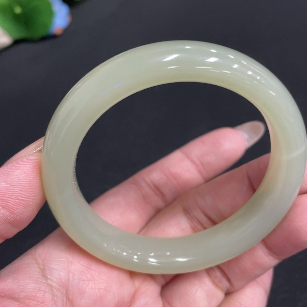 Huiliu Certified Hetian Jade Round Bangle showing smooth, polished jade surface with natural green and white tones.