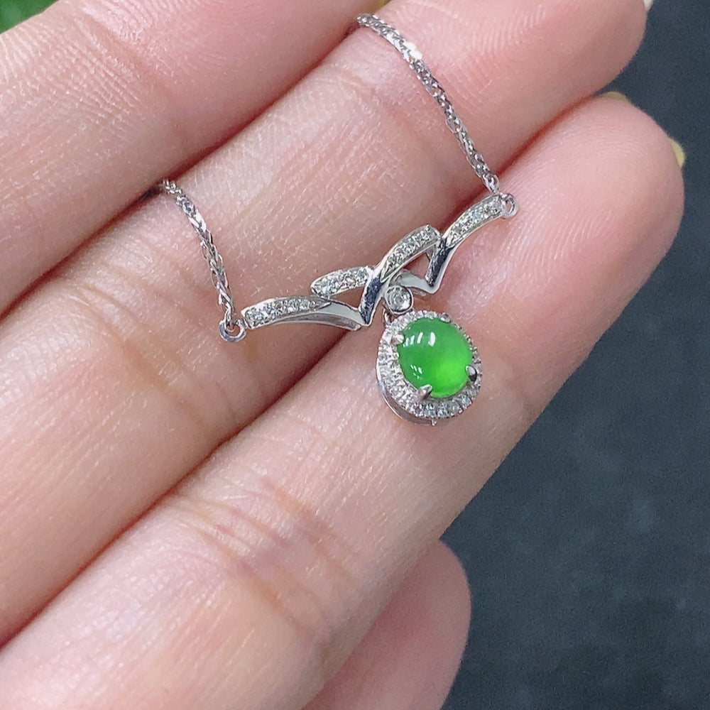 Jadeite cabochon pendant with 18K gold setting and diamond accents, featuring a polished green jade stone and elegant design.