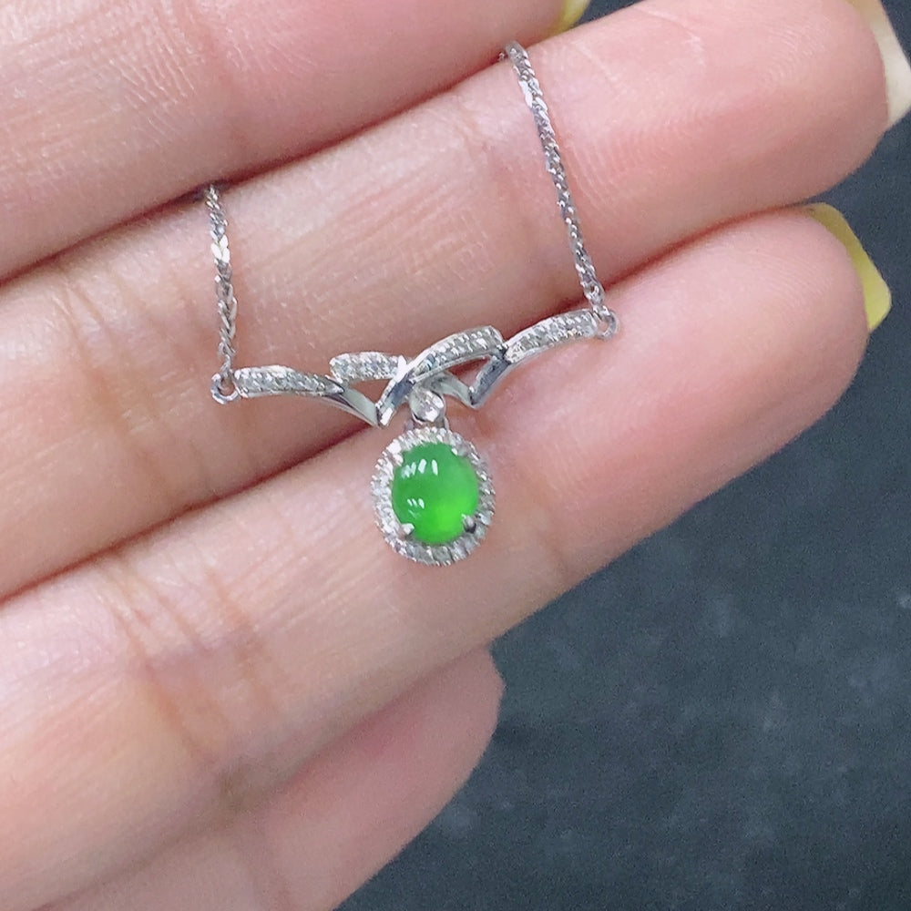Jadeite cabochon pendant with 18K gold setting and diamond accents, featuring a smooth, polished jade stone in a jewelry image