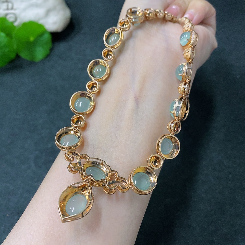 Jadeite cabochon necklace with 18K gold accents and diamond details, featuring a green jade pendant on a gold chain.