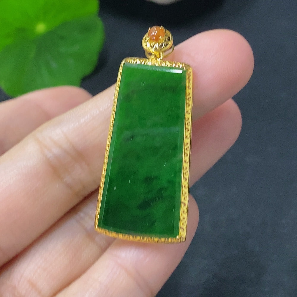 HUILIU HQ jadeite inlaid pendant with 18k gold, weighing approx. 2g, featuring mineral components, on a jewelry display.