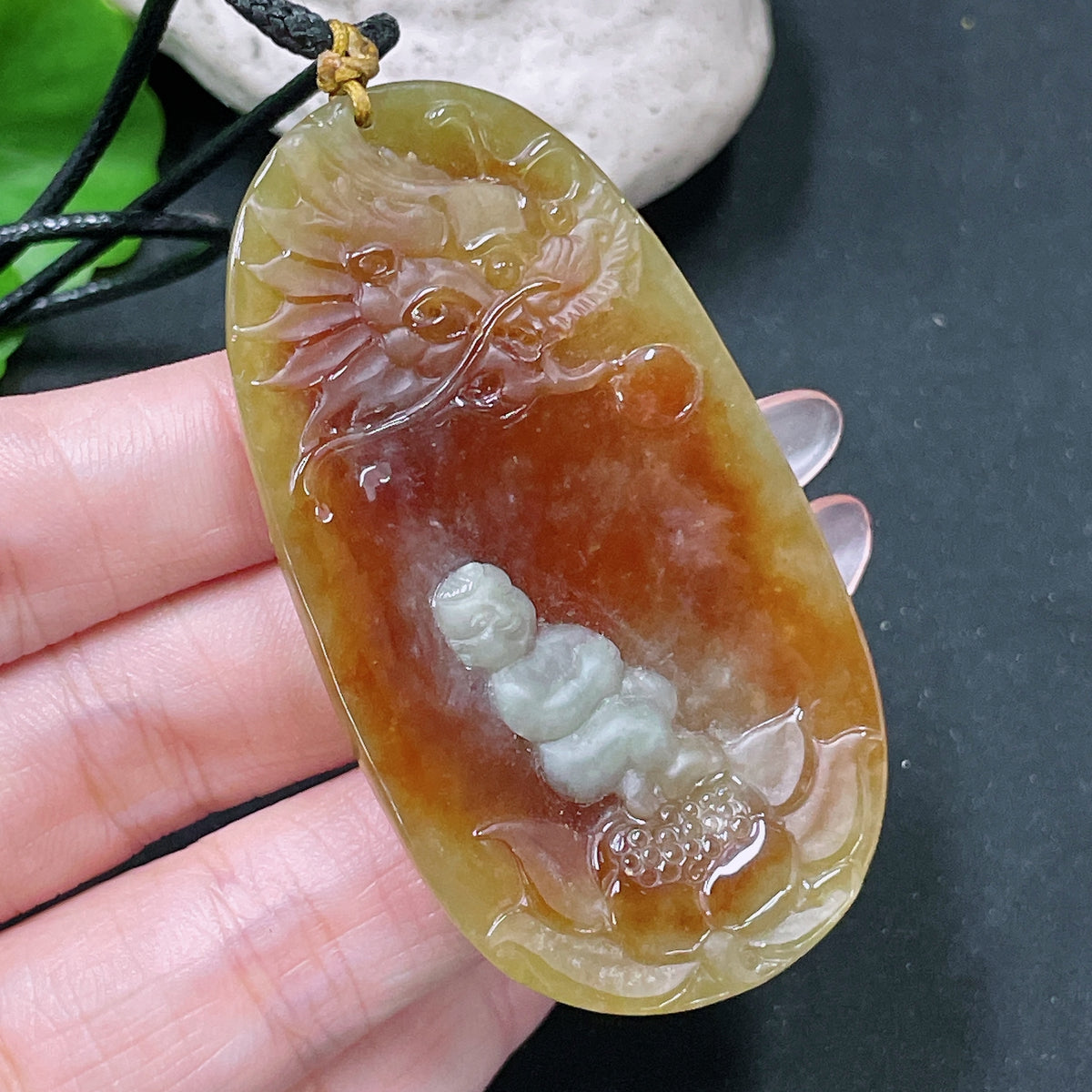 HUILIU HQ jadeite lotus pendant weighing about 36.65g with yellow-colored jade, displayed with rope, natural stone appearance.