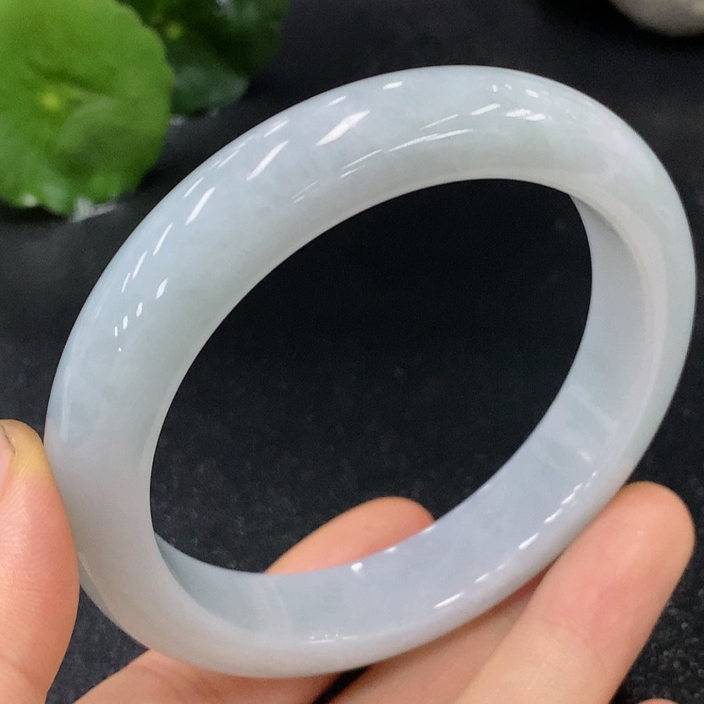 Huiliu Certified Jadeite round bangle showcasing smooth, glossy green jade with intricate natural patterns and a polished finish.