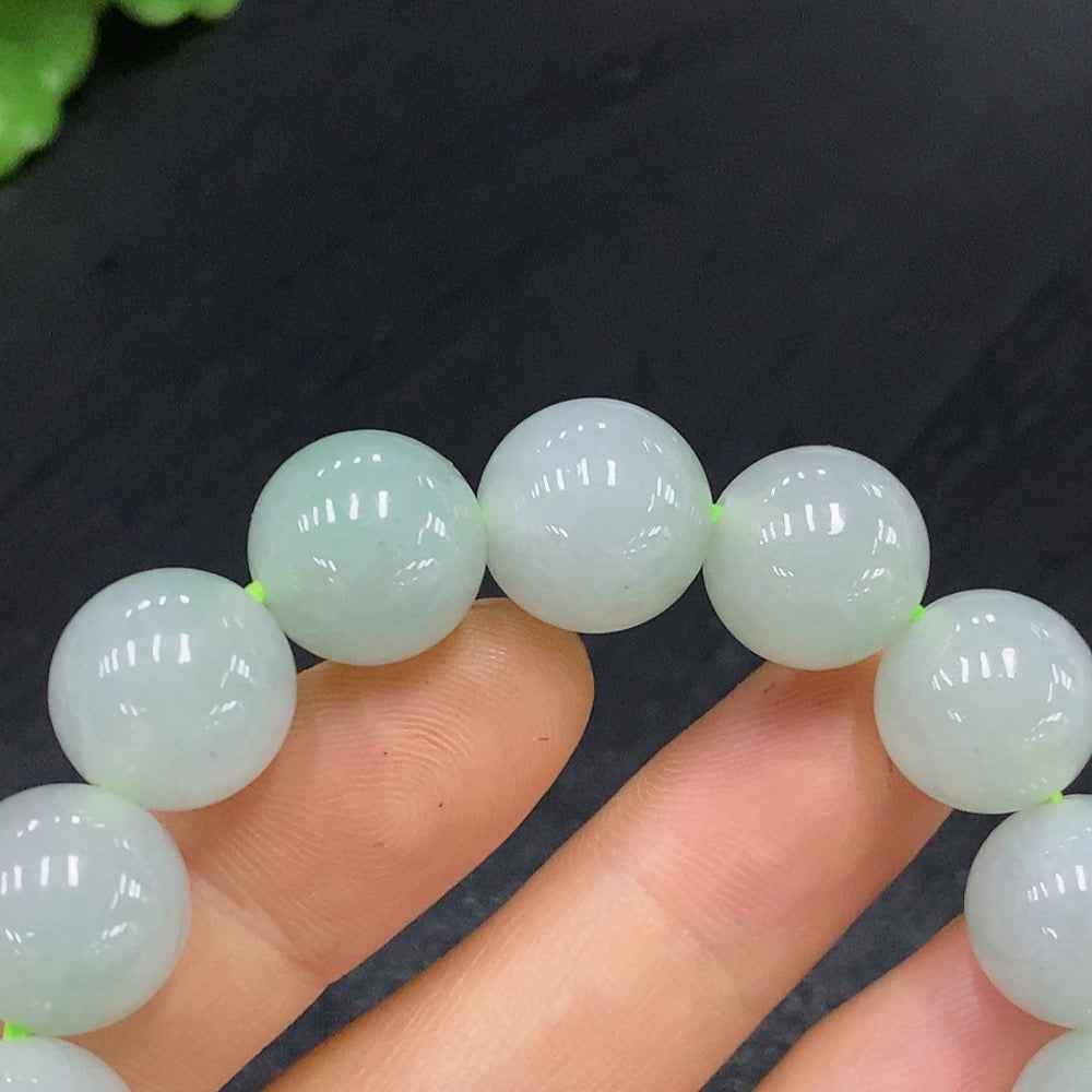 Huiliu Certified Jadeite bead bracelet with 12.5mm smooth green jade beads, showcasing natural luster and craftsmanship.