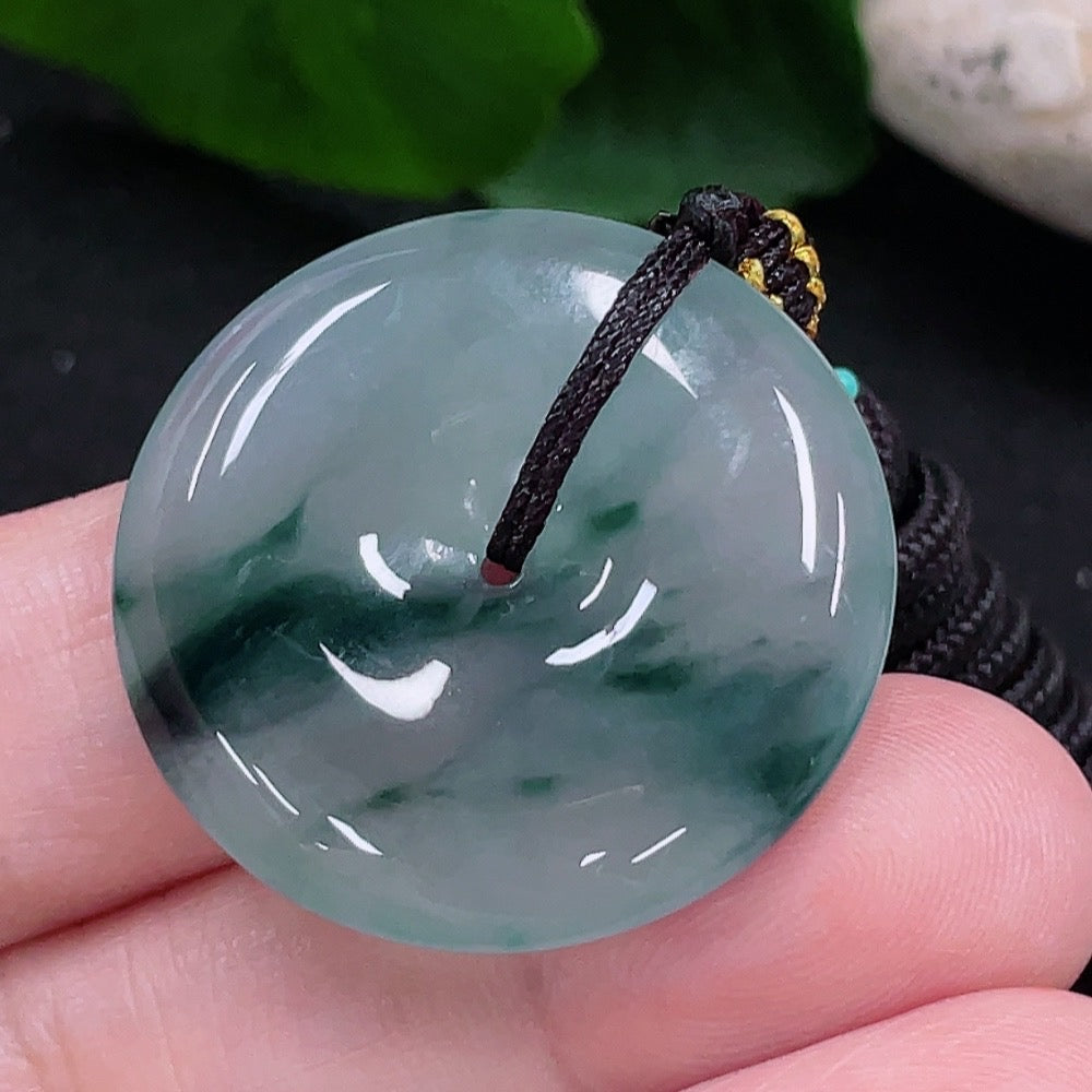 HUILIU HQ JadeitePeace buckle pendant featuring a smooth green jadeite jade stone with carved design, hanging from a cord.