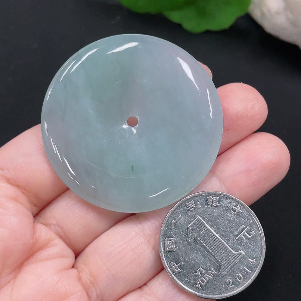 HUILIU HQ jadeite Peace button pendant with smooth green jade surface and carved design, hanging from a delicate cord.