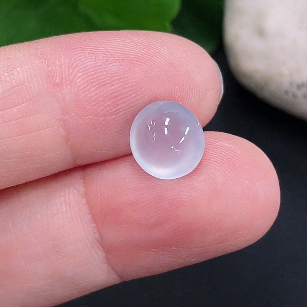 Close-up of a green jadeite cabochon from HUILIU HQ, weighing approximately 0.6g, showcasing smooth, polished surface and vibrant color.