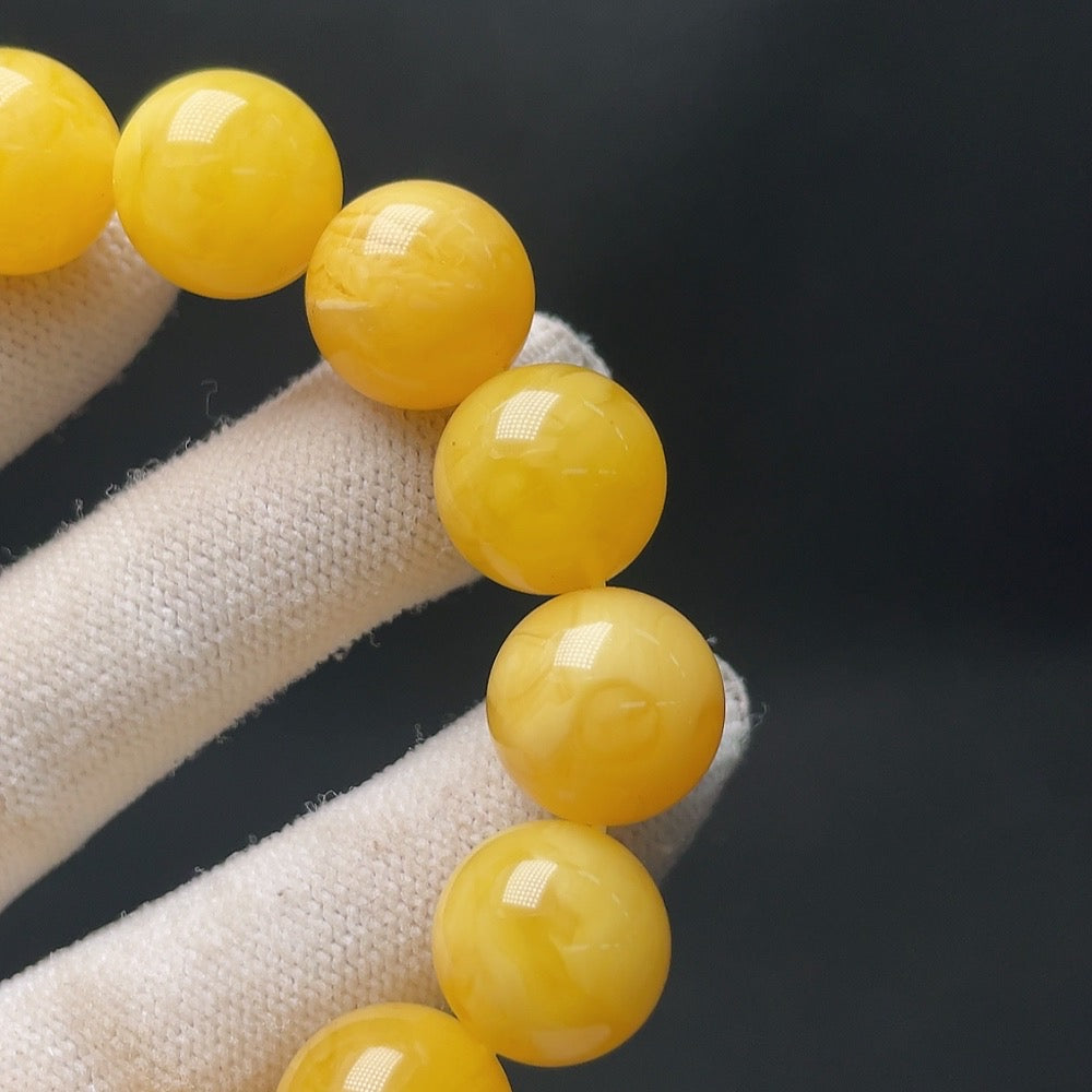 Amber beeswax bracelet by HUILIU HQ with 14.1mm beads, weighing approximately 23.8g, showcasing warm amber tones and natural craftsmanship.