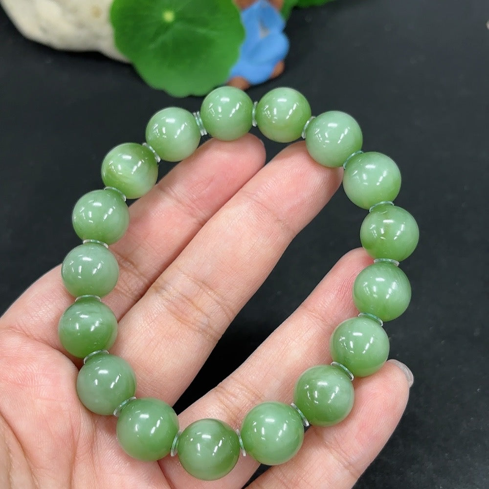 Green Hetian Jade bracelet featuring smooth, polished jade beads from HKHQ, showcasing elegant craftsmanship and vibrant green color.