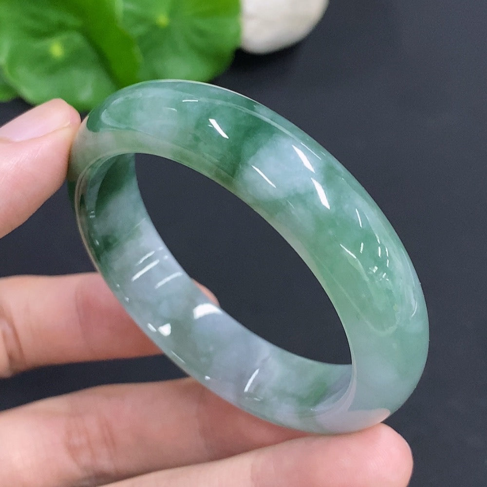 HKHQ Jadeite oval bangle, size 53, 38.1g, showcasing smooth, polished green jadeite bracelet on a neutral background.