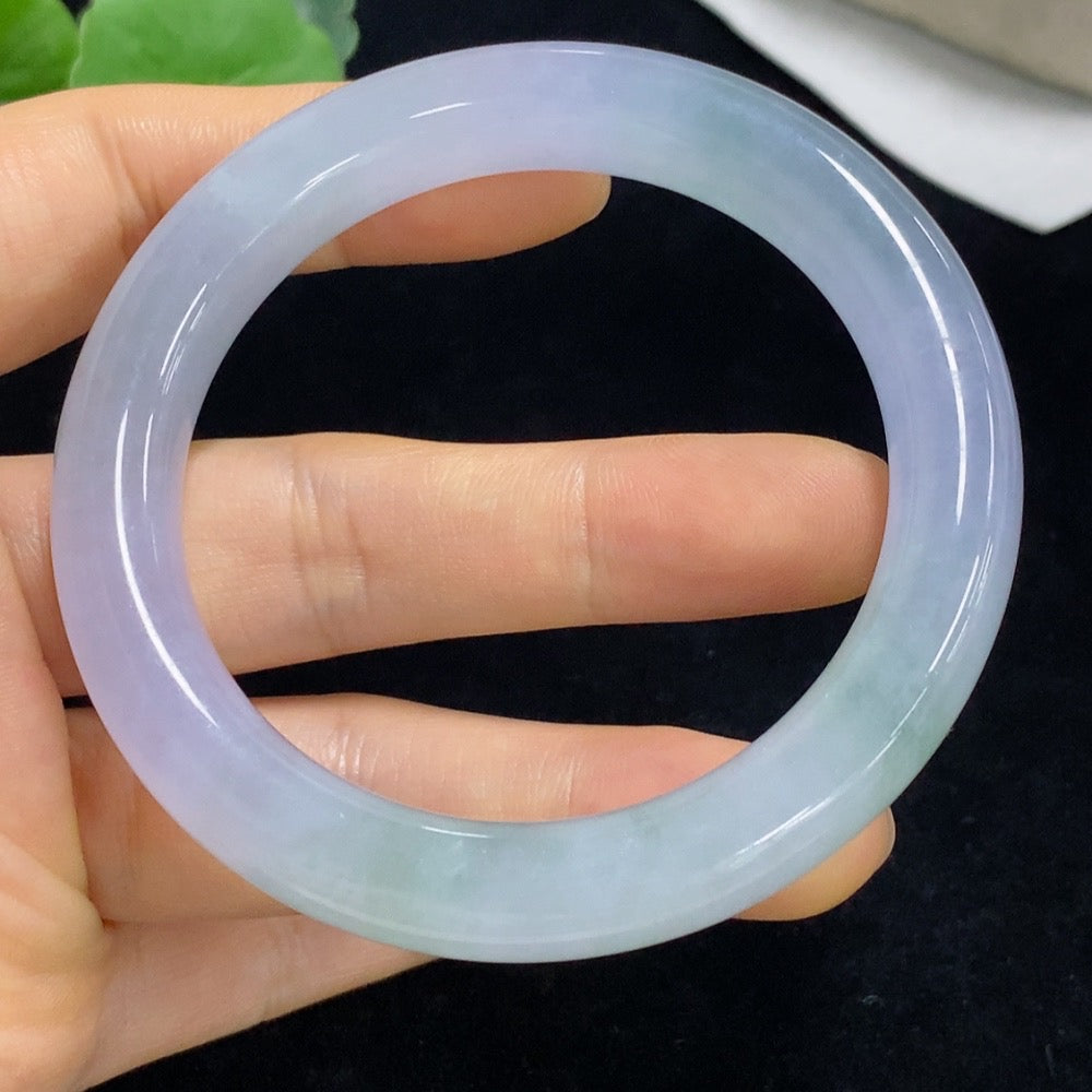 Huiliu certified jadeite round bangle on a display, showcasing smooth, polished green jade jewelry with a glossy finish.