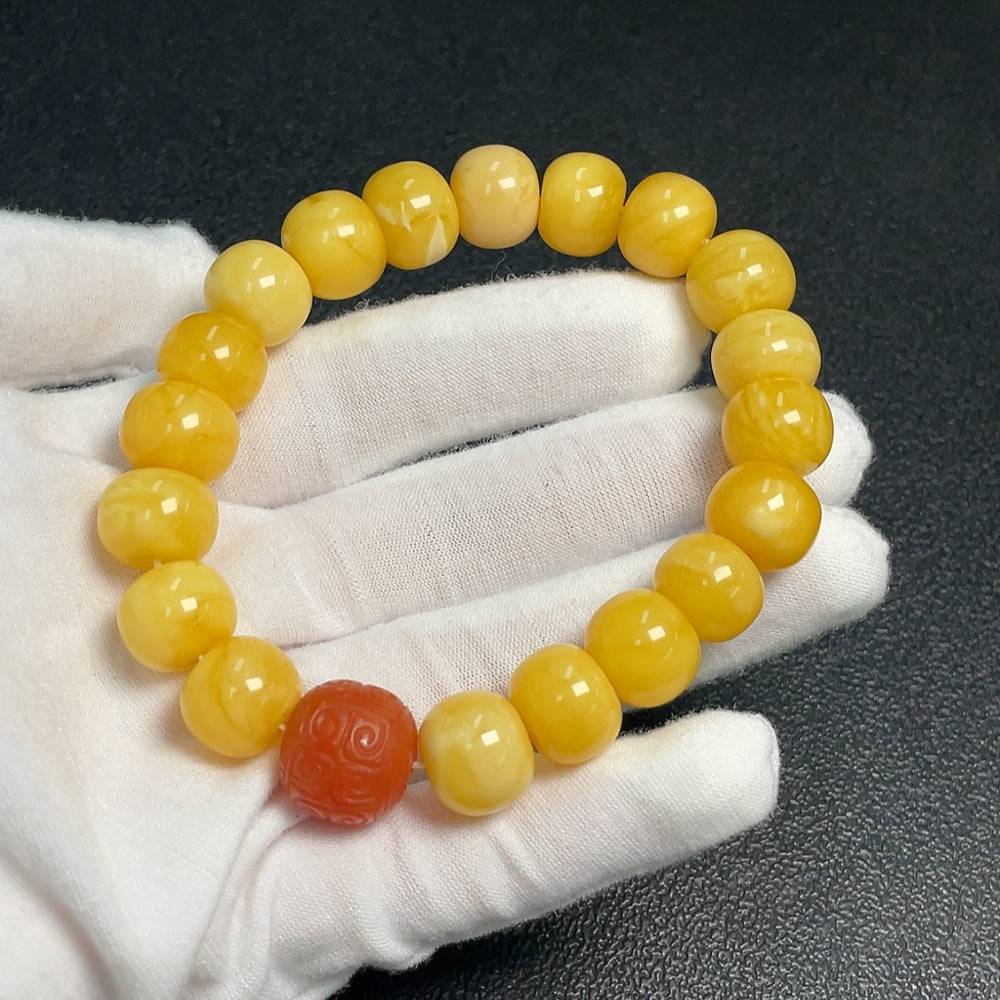 Amber beeswax bracelet with Southern Red Agate beads, handcrafted by HUILIU HQ, showcasing warm amber tones and vibrant red accents.