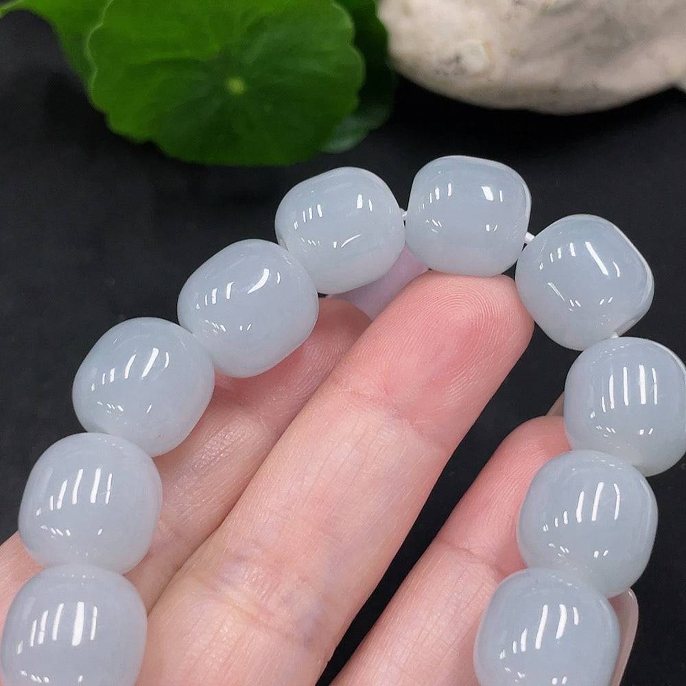 Huiliu jadeite bracelet with 12.8mm beads, featuring polished green jade stones on a clear string.