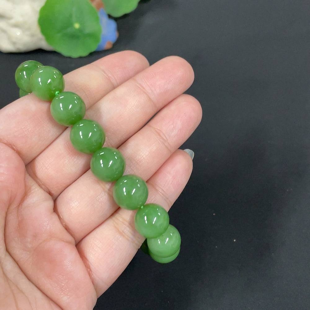 Huiliu certified Hetian jade bracelet with 11.8mm smooth round beads, showcasing rich green jade color and fine craftsmanship.