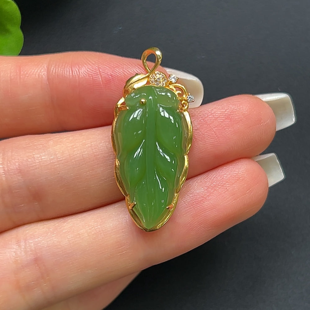 Green Hetian jade leaf pendant necklace with 18K gold setting, featuring a smooth jade leaf design on a fine chain.