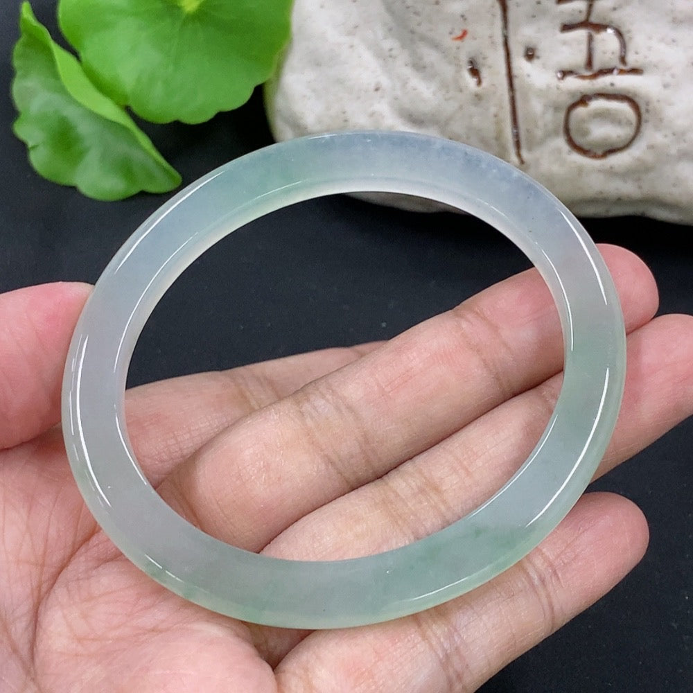 HKHQ jadeite oval bangle in size 55.3 with a 24.3g weight, showcasing smooth, polished jadeite with elegant oval shape.