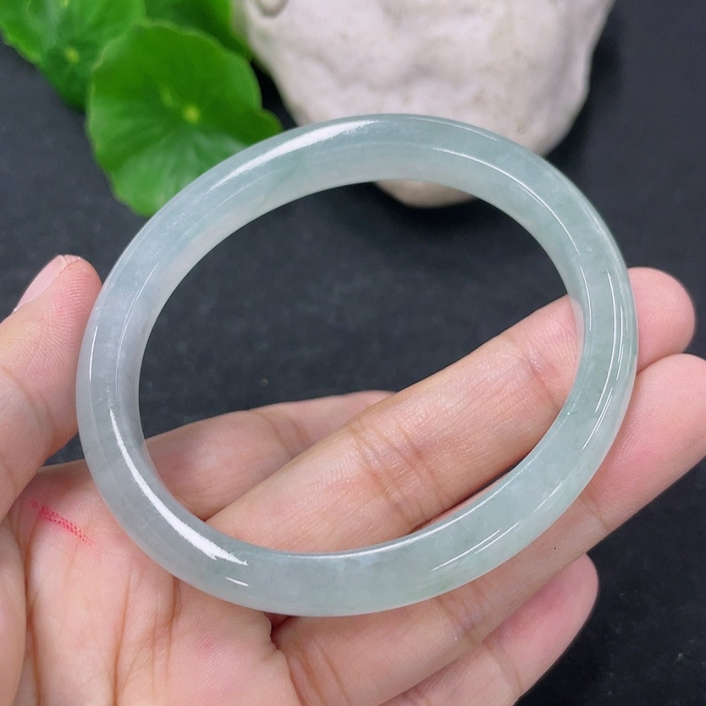 HKHQ jadeite oval bangle in size 52.8 with 27.69g, showcasing smooth polished jadeite bracelet on a neutral background.