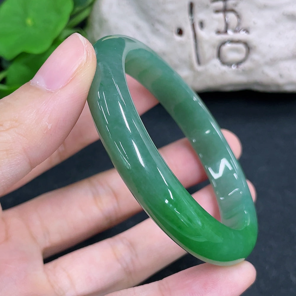 HKHQ jadeite round bangle in size 54, weighing 38.5g, featuring a smooth, polished green jadeite bracelet on a display.