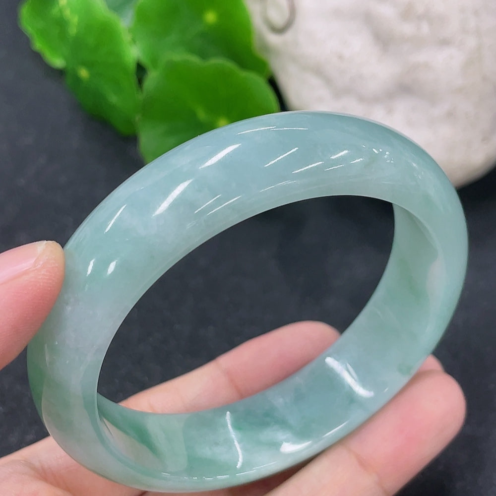 HKHQ jadeite round bangle in size 54.7 with 57.3g, showcasing smooth, polished green jadeite bracelet on a neutral background.