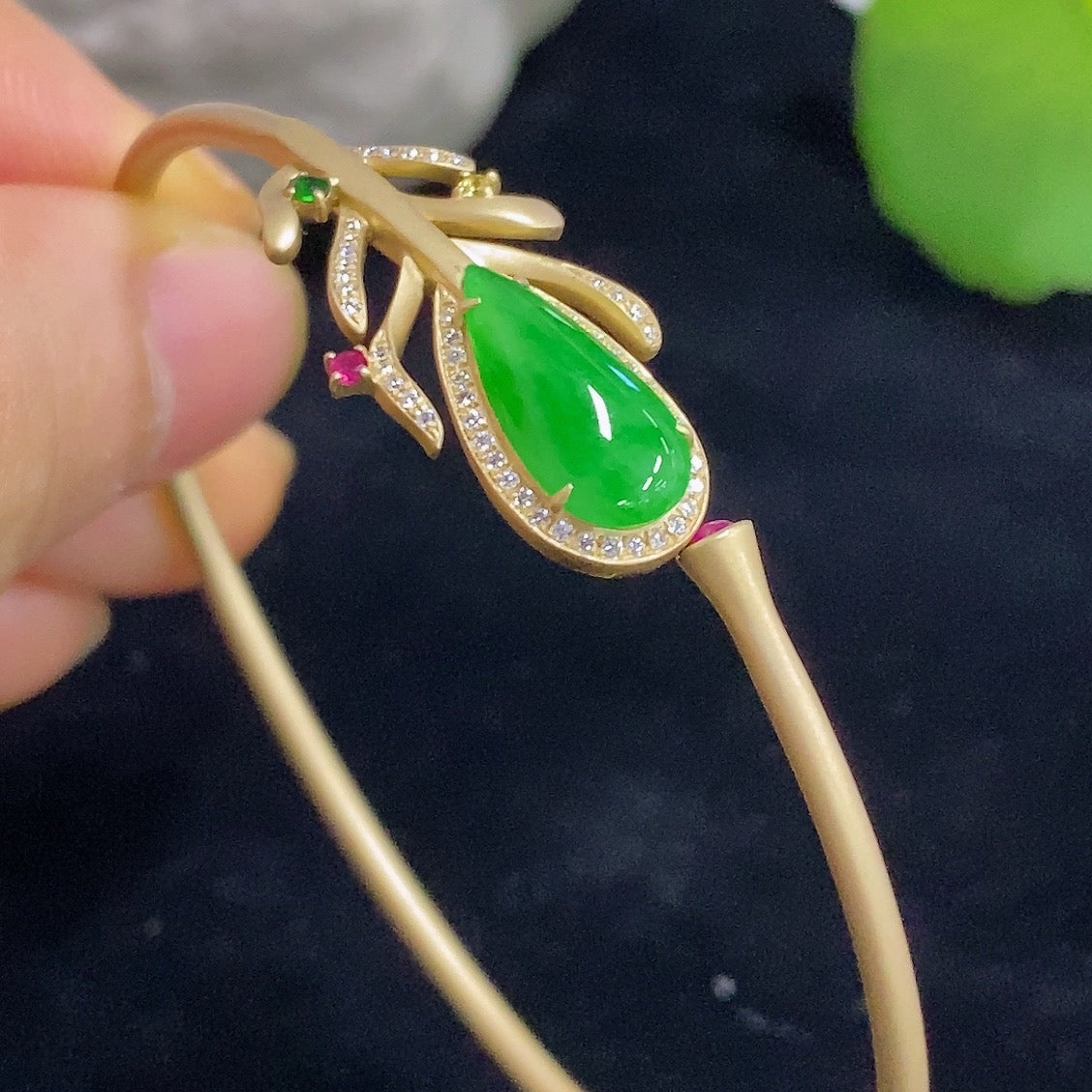 Elegant Jadeite bangle in 18K gold with sparkling colorless diamond accents, showcasing luxurious bracelet craftsmanship.