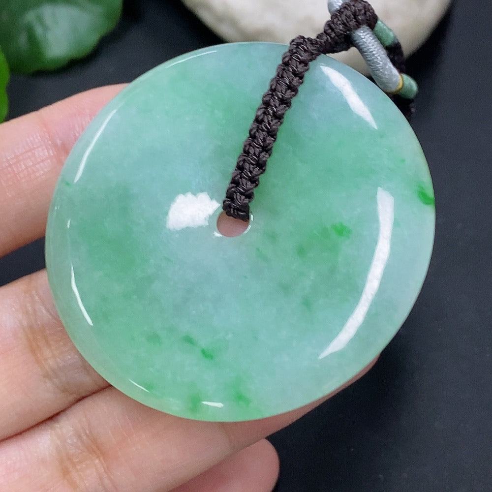 Jadeite pendant with peace knot design, weighing 28.34g including cord, crafted by HKHQ in vibrant green jade.